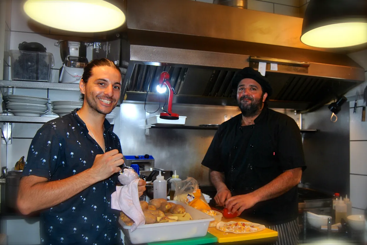 Dos personas del equipo sonriendo en la cocina de ANDINO