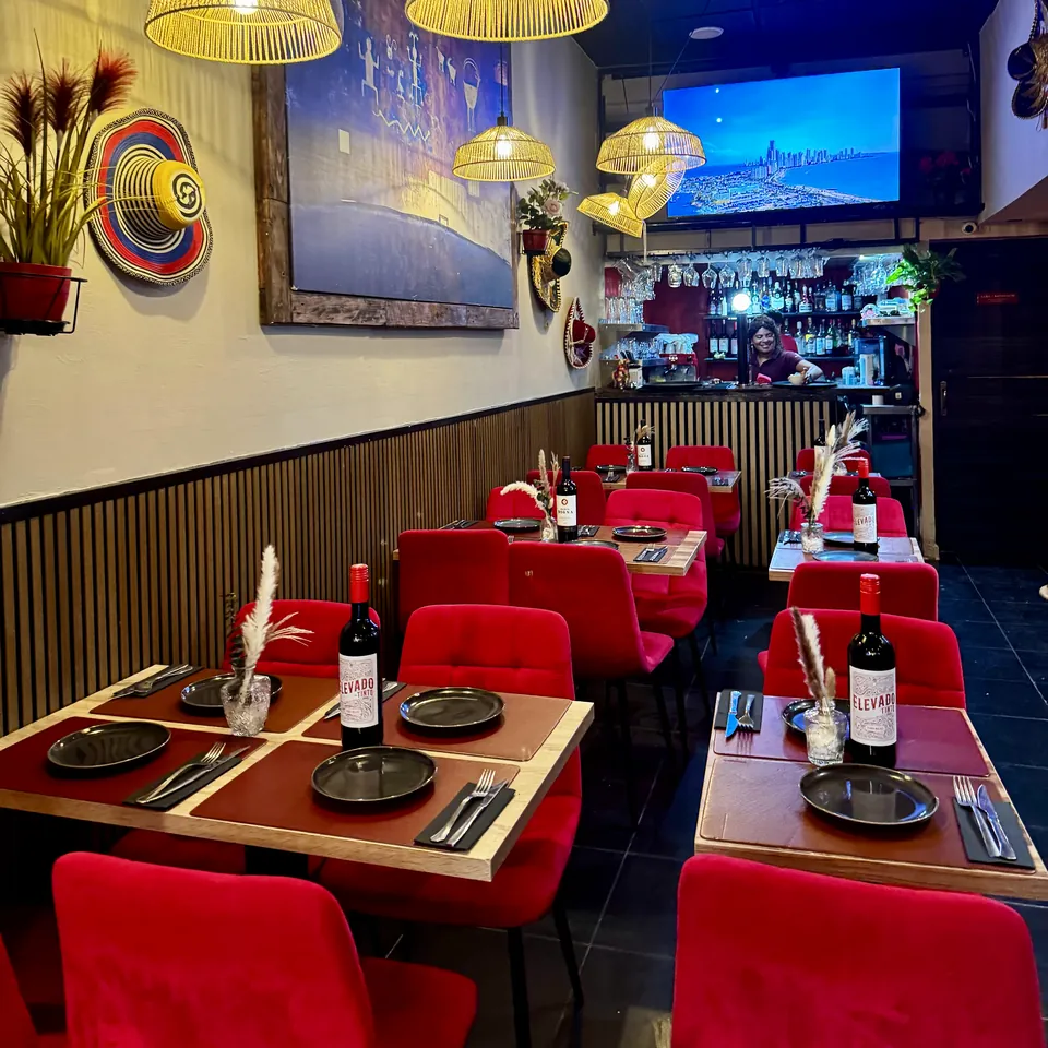 Comedor de ANDINO con sillas de terciopelo rojo y lámparas de mimbre
